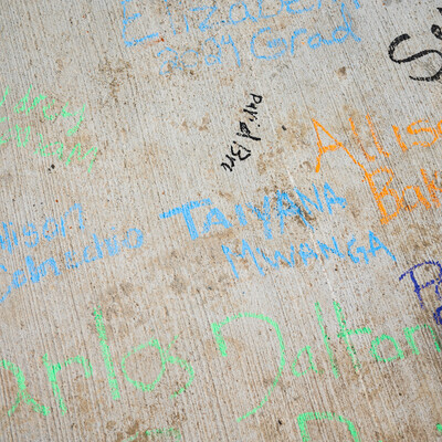 Blue, orange, black, and green signatures cover the face of a newly constructed bridge.