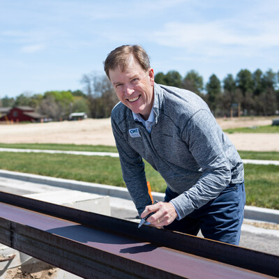 CWI president Gordon Jones signs his name on a metal beam destined for a new Health and Sciences building.