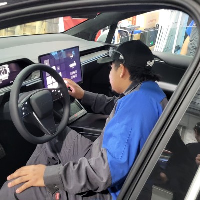 Student using Tesla controls in vehicle