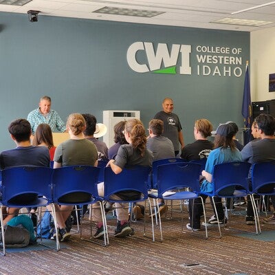 Group of people in a classroom listening to speakers