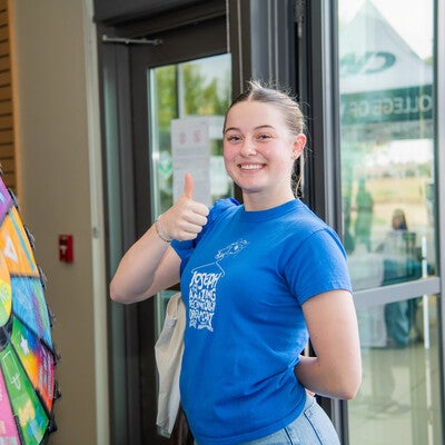 Student smiles with thumbs up with spin wheel