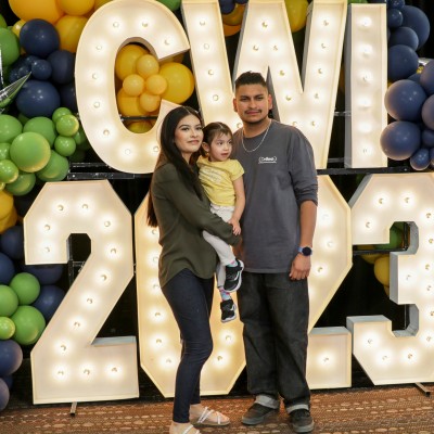 Family posing in front of CWI 2023 sign 