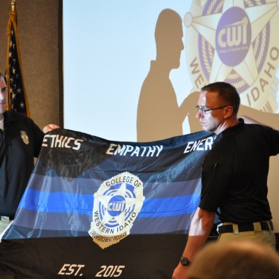 A class flag is presented by graduates at the Law Enforcement program ceremony.