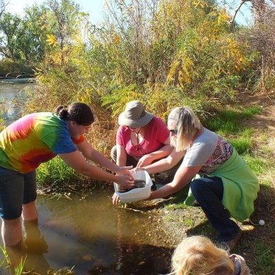 Three women collecting water samples.