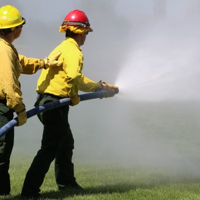 Firefighters spraying a fire with hose
