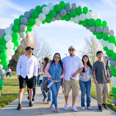 Students and family walk underneath a balloon archway as they attend the 2024 CWI Grad Fest.
