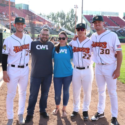 CWI graduate, Ashton Syed, and his wife posing with Boise Hawks players