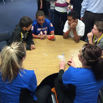 Dental Assisting students sitting with kids at table.