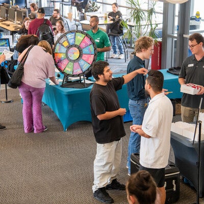 Students gather around tables with activities and food