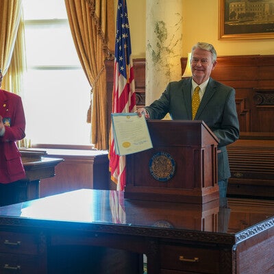 Governor stands behind podium with proclamation in hand