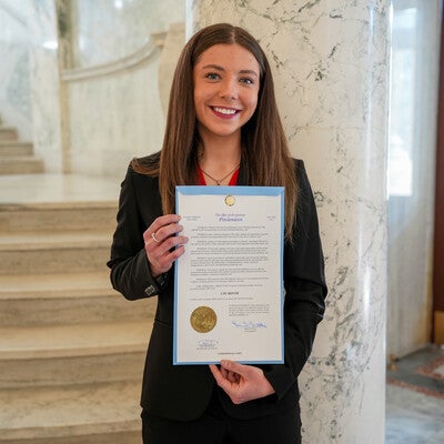 Person holding a signed proclamation on the Capitol steps