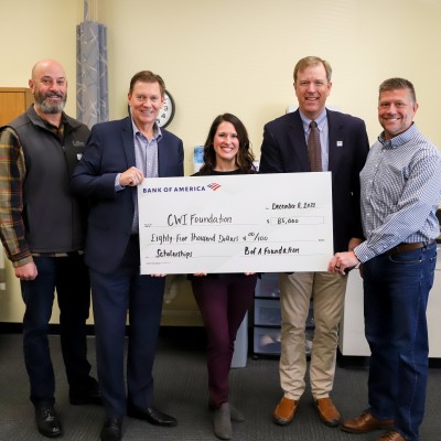 College and Bank leadership holding a check