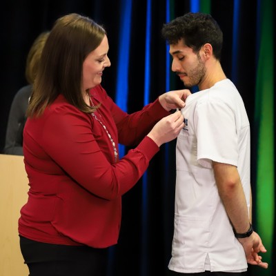 Instructor pinning student at 2022 pinning ceremony