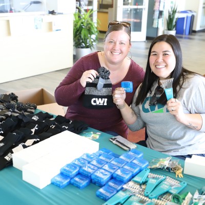 Staff handing out CWI swag at Grad Fest
