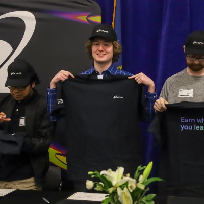 Micron Apprentice, Ian, holding up a t-shirt for signing day