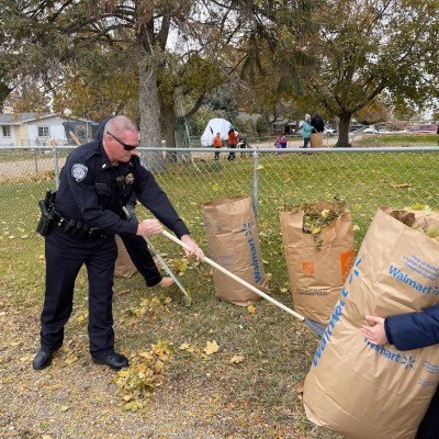 Sheriffs Deputy raking up leaves