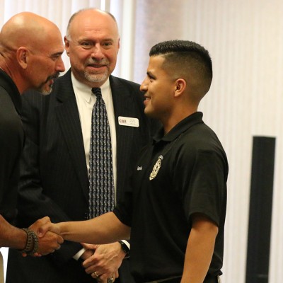 Reid shaking a student's hand at the Law Enforcement graduation ceremony