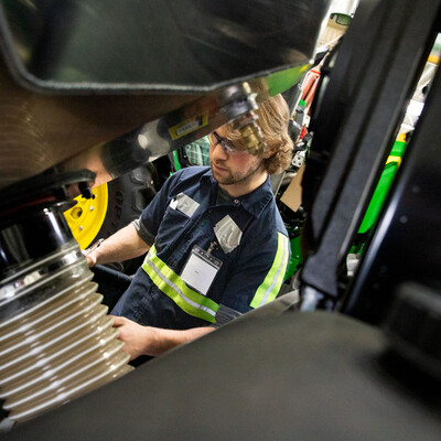 A student performs maintenance on a tractor.