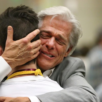 Mike Faylor, a 2019 Professional Nursing Graduate receiving a congratulatory hug after pinning ceremony