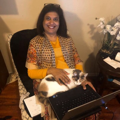 Sabina Omair working from home with her cat as a coworker