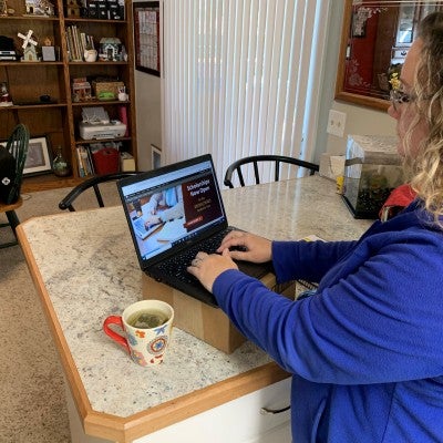 Stacy Hardy working from home with a makeshift stand-up desk for her laptop