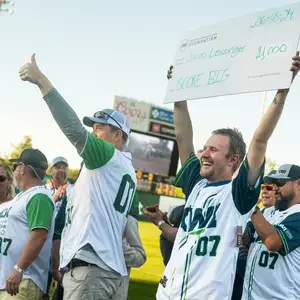 Student holding large check in front of crowd