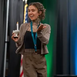 Graduate with candle walking across stage