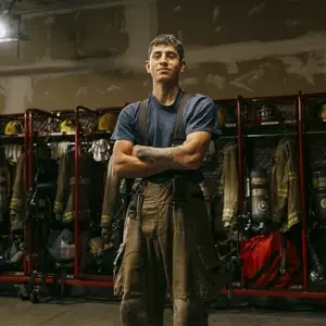 Marquez Arredondo poses in front of firefighter gear