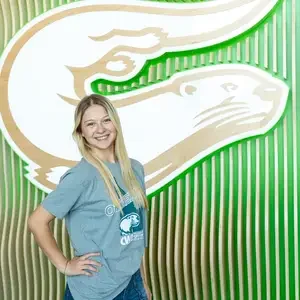 Student stands in front of otter logo