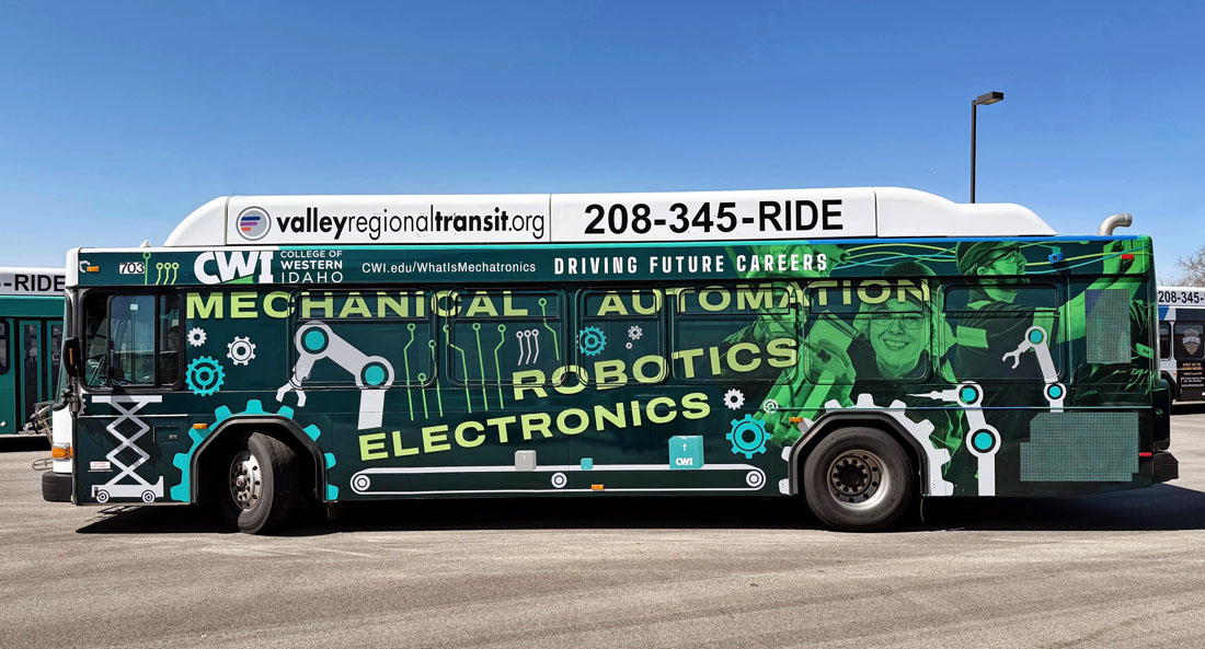 A city bus with a mechatronics-themed vinyl wrap.
