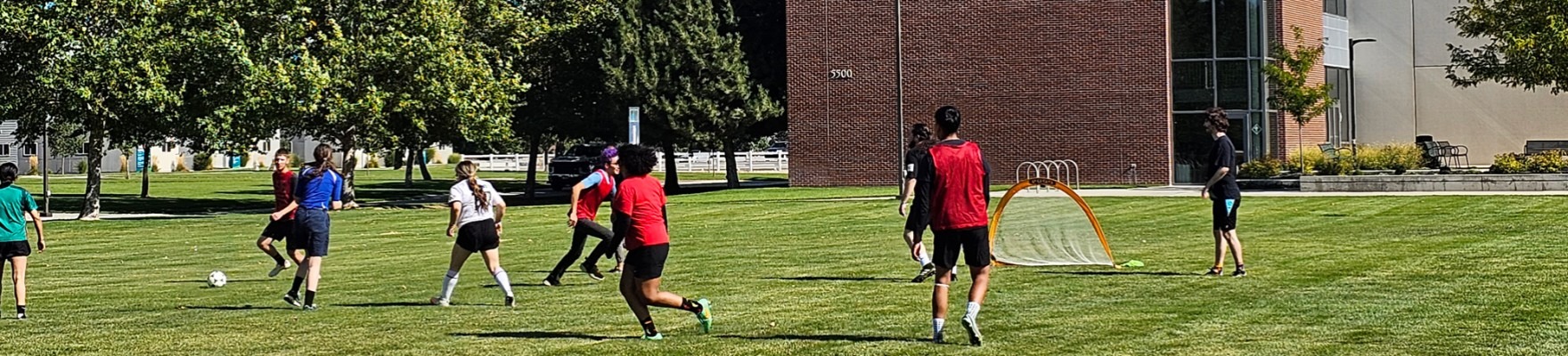 Club members playing soccer outside of the Nampa Campus Academic Building