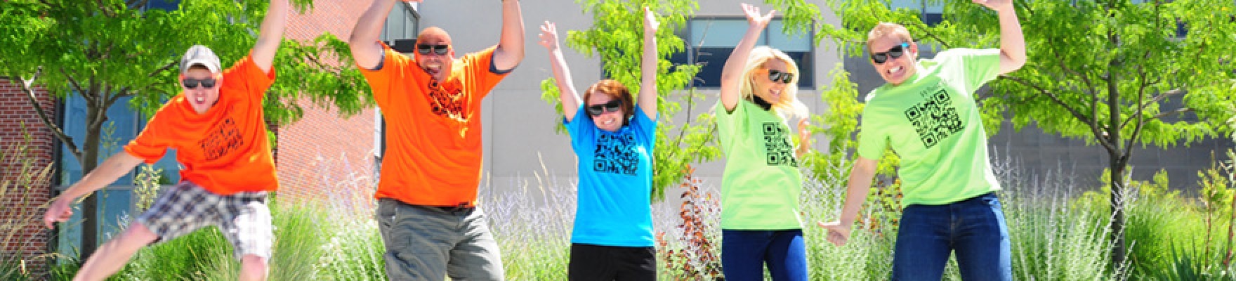 five street team members jumping while wearing brightly colored shirts