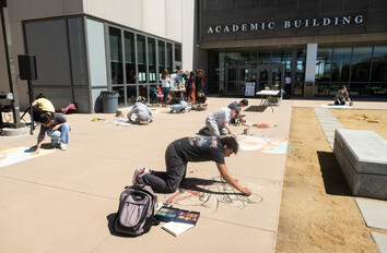 Students drawing on sidewalk