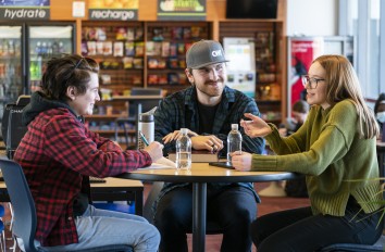 Student talking at table in common area