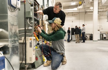 Instructor working with student on furnace