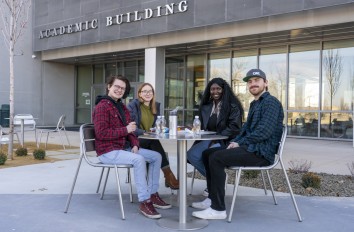 Students at a table outside the Academic Building