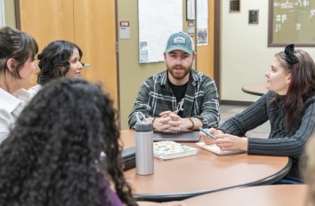 Students talking at a table in a classroom