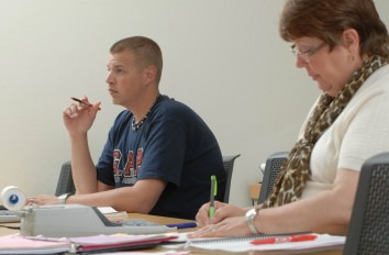 Close up of students taking notes in class.