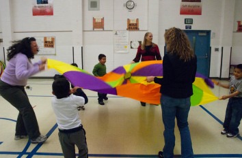 Education students and young children with parachute.