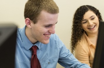 Close up of two business students working on a computer.