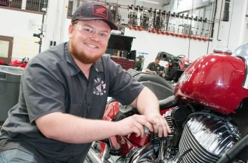 Powersports student working on a red Indian motorcycle