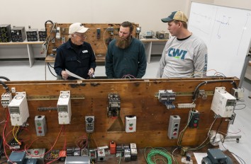 Students in lab with instructor with electrical workbench