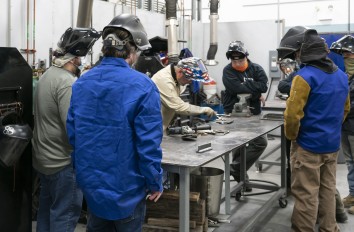 Students watching instructor in welding lab