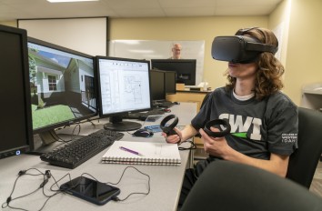 Drafting student with virtual headset on in front of computer