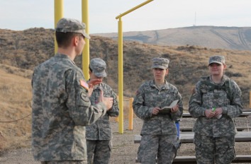Four military science students receiving a briefing during training