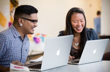 Two students studying on Apple Macbooks