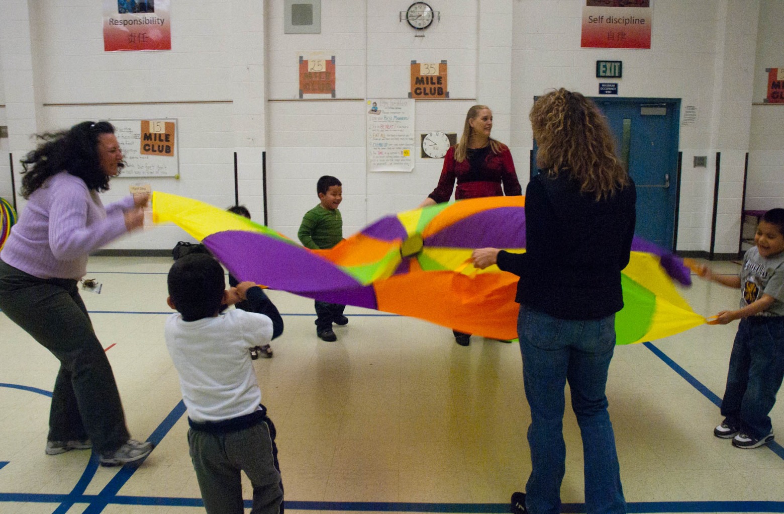 Education students and young children with parachute.