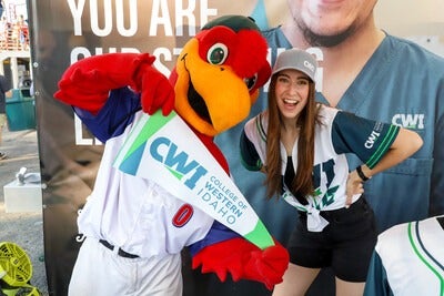 Hawks mascot with a CWI employee holding a CWI banner