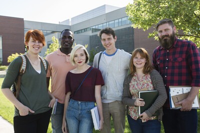 group of students posing outside a campus building for a photo
