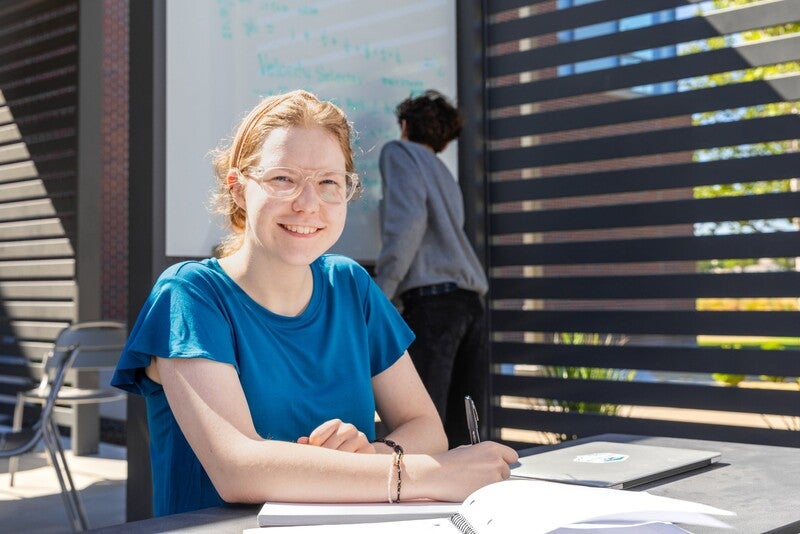 Student studying in outdoor common area on campus